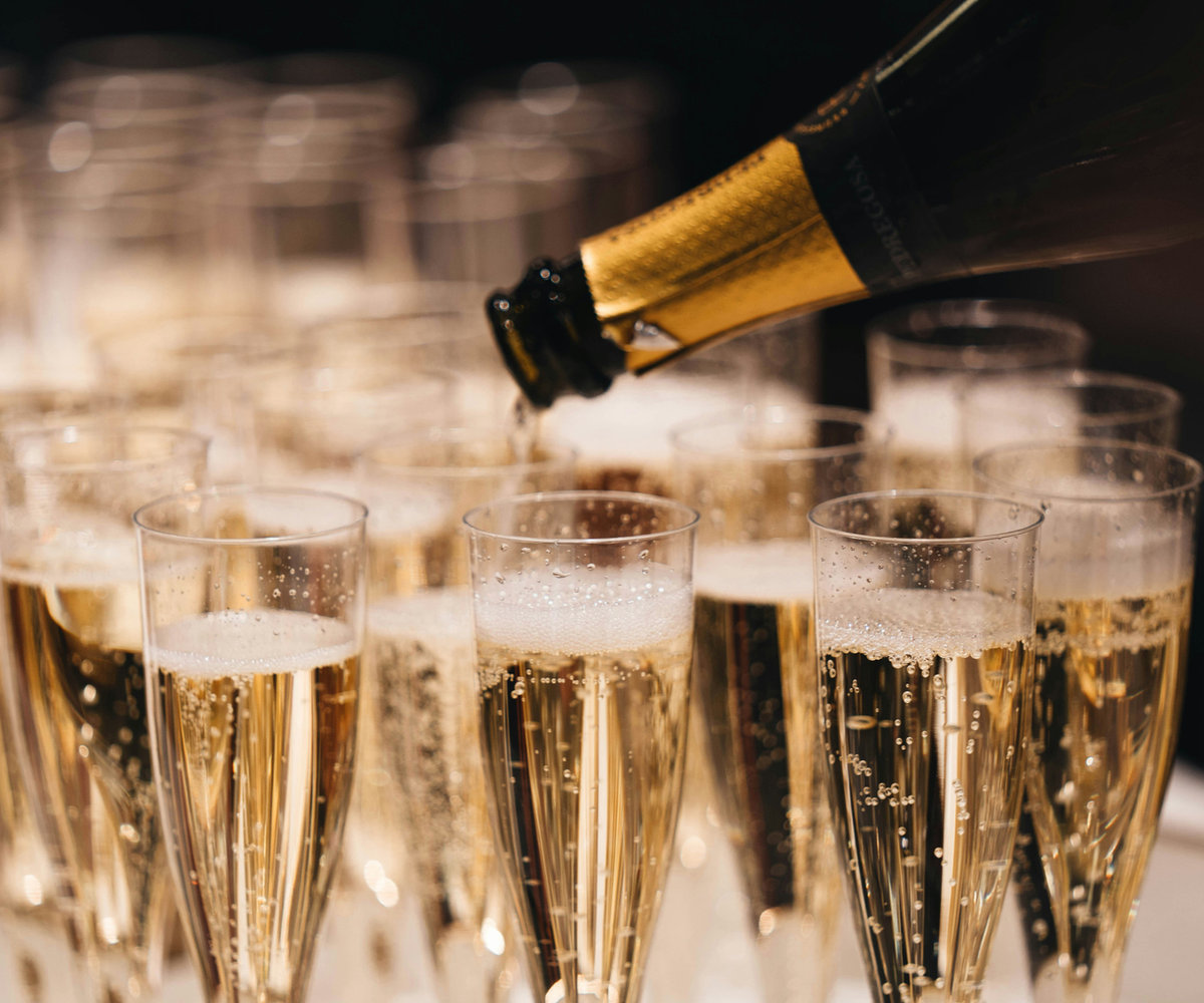 Champagne poured into rows of glasses at a wedding reception