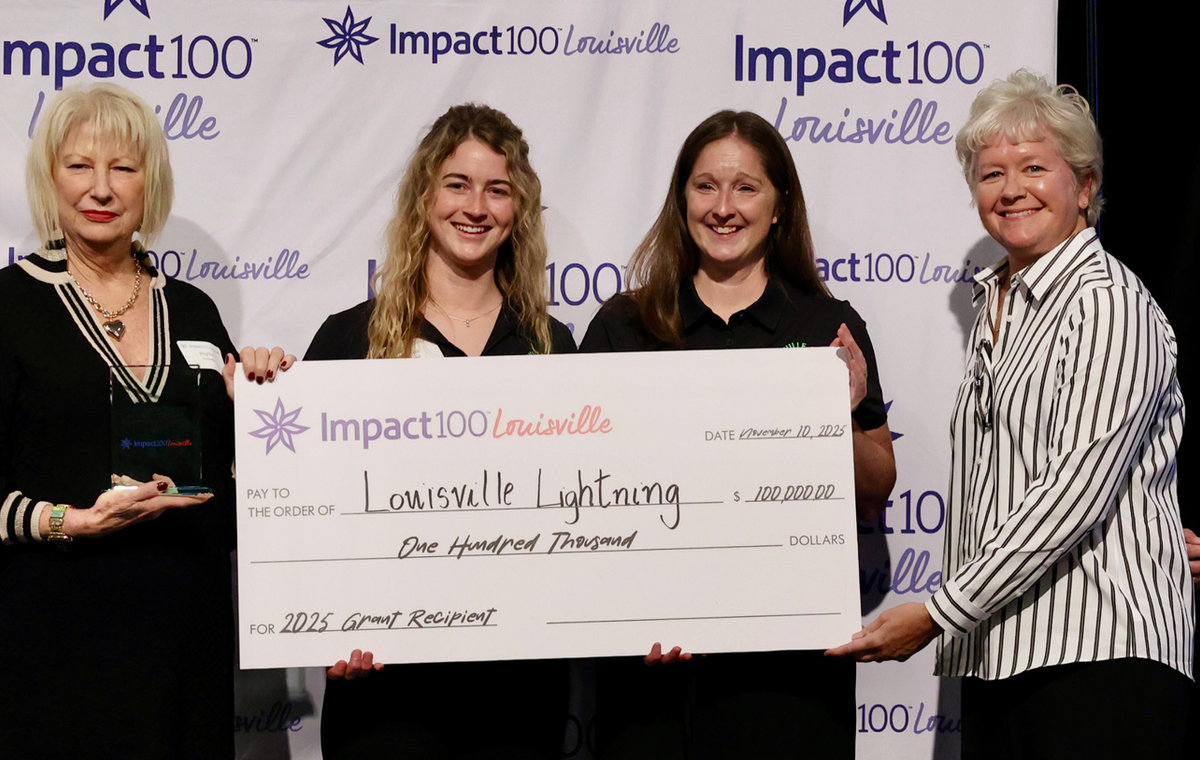 Impact100 Louisville grant recipients holding a large ceremonial check